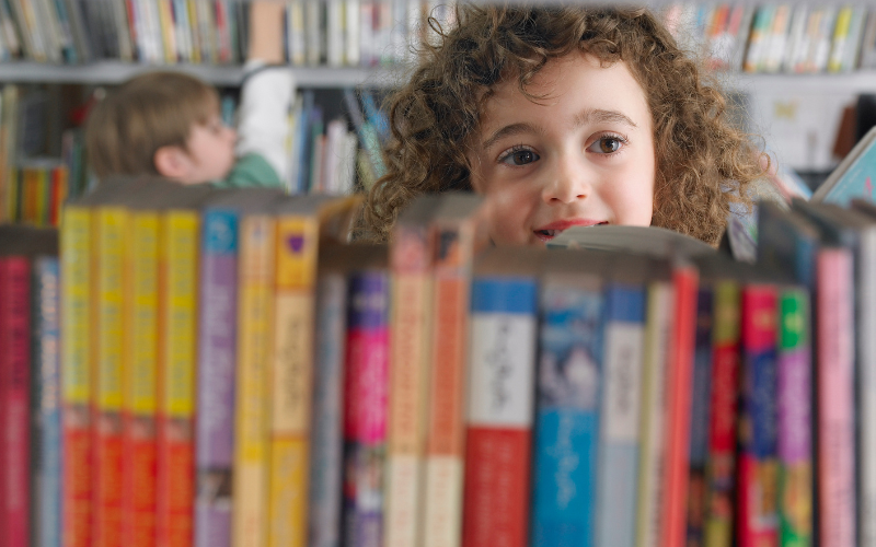 young girl looking at books